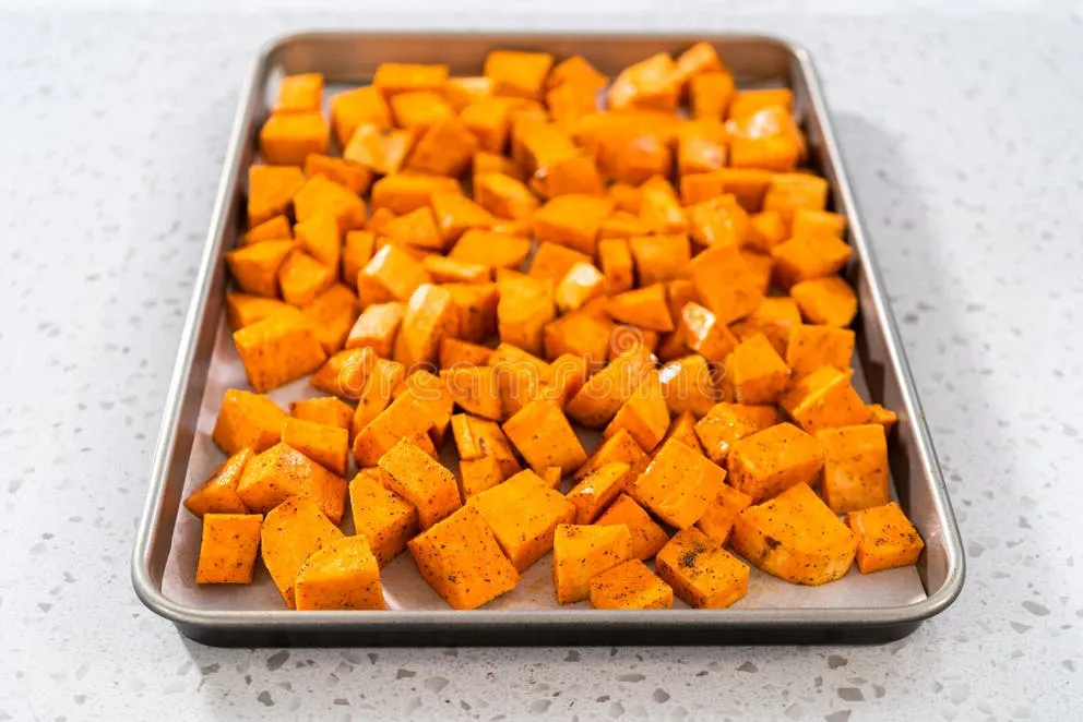 Sheet pan filled with spiced chickpeas and cubed sweet potatoes ready for the oven